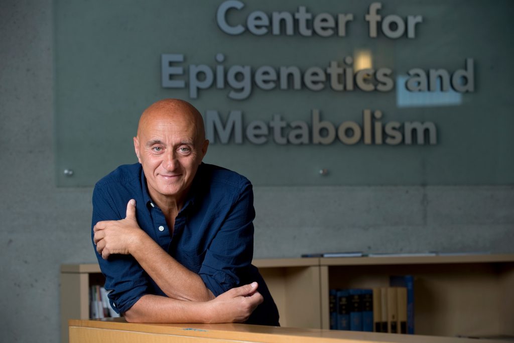 Der unlängst verstorbene Epigenetiker Paolo Sassone-Corsi von der University of California in Irvine vor einem Schild seines Instituts: Center fpr Epigenetics and Metabolism.